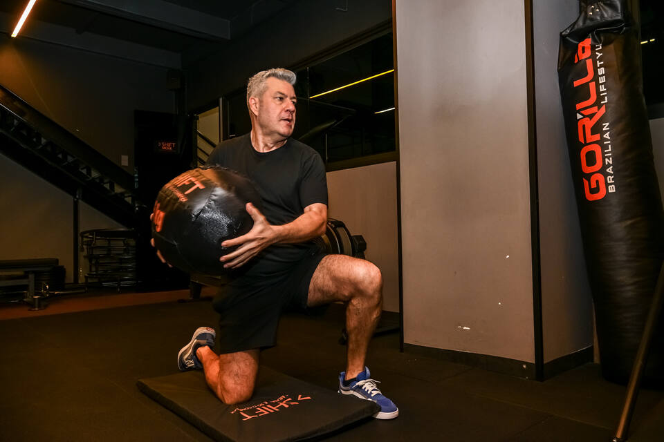 Aluno fazendo rotação com medicine ball no salão da SHIFT